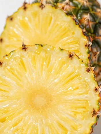 Frisk, skiveskåret ananas på rustikt træbord