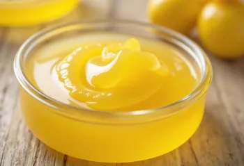 Ghee i glas og på ske, på træbræt i naturligt lys
