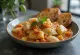 Caponata med fisk serveret med tomatsauce og oliven