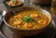 Gullig sambar linsesuppe med gulerodsskiver og urter