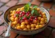 Ghugni chaat med gule ærter, serveret med friske korianderblade og tamarind chutney