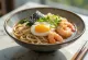 Onsen Tamago i udon-suppe serveret med frisk æg, rejer og skaldyr