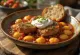 Nakkekotelet i lecsó med nokedli og creme fraiche serveret