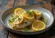 Stegt fisk serveret med citron og krydderurter