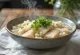Cháo med fisk, hvide ris, fisk og frisk koriander serveret