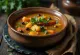 Klar rasam suppe med tamarind serveret med frisk koriander